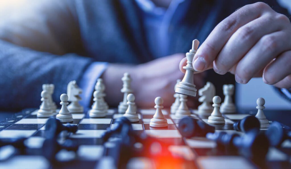 a person playing chess with a white piece