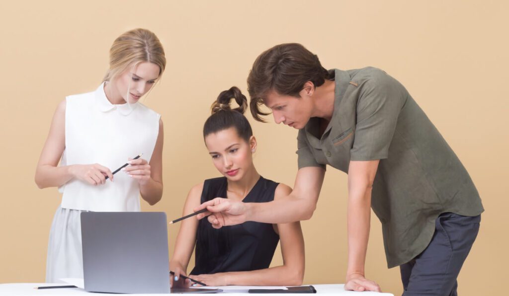 a group of people looking at a laptop