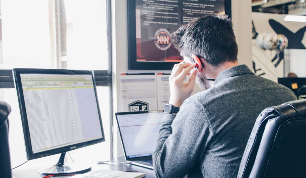 a person sitting at a desk with a laptop and headphones