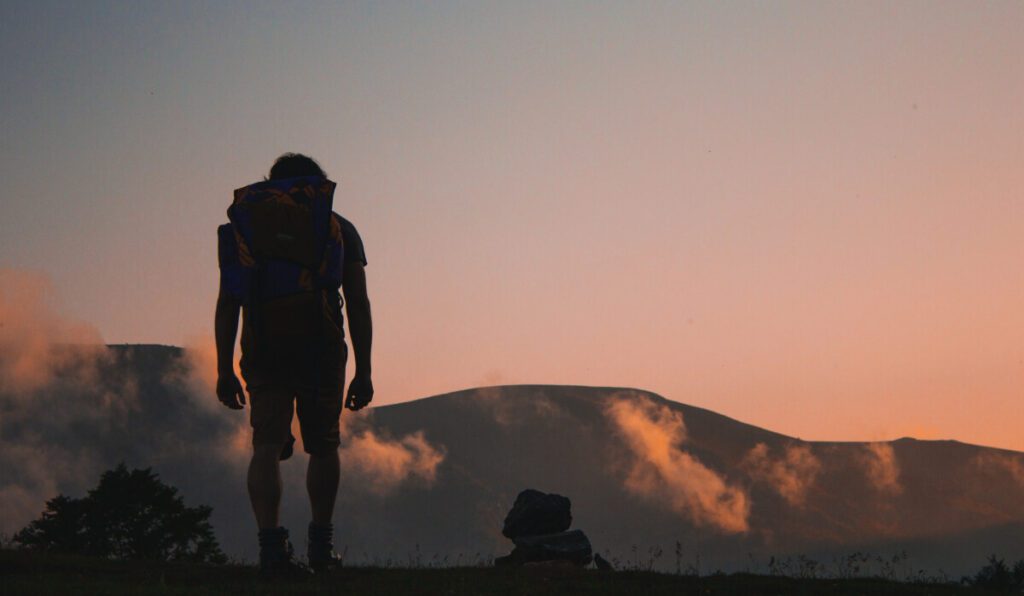 a person standing in front of a mountain